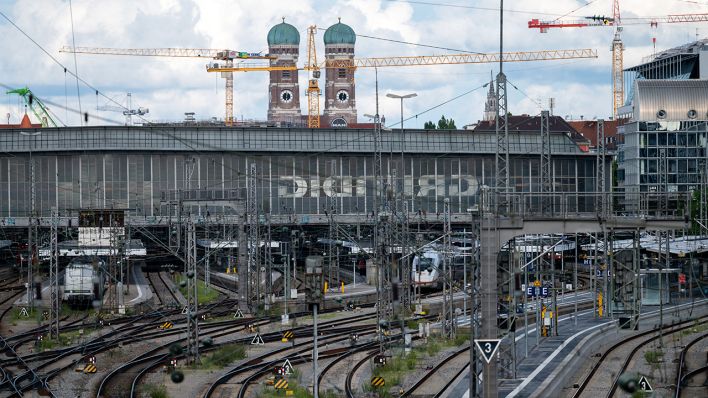Die Türme der Frauenkirche sind zwischen Kränen hinter dem Hauptbahnhof in München zu sehen. (Quelle: dpa/Sven Hoppe)