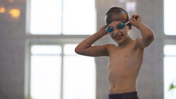 Ein Kind mit Schwimmbrille in einer Schwimmhalle (Quelle: dpa)