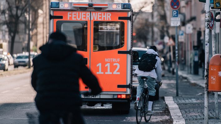 Fahrradfarhrer fahren in Berlin auf der Strasse auf einen parkenden Rettungswagen der Feuerwehr zu. (Quelle: dpa/Zacharie Scheurer)