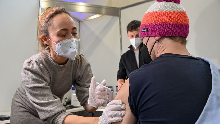 Kinderärztin Lisa Freude impft einen Mann in einer der fünf Impfstraßen in der Schinkelhalle. (Quelle: dpa/Jens Kalaene)