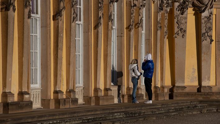 Eng beieinander steht ein Paar am ersten Weihnachtstag vor dem Schloss Sanssouci. (Quelle: dpa/Paul Zinken)
