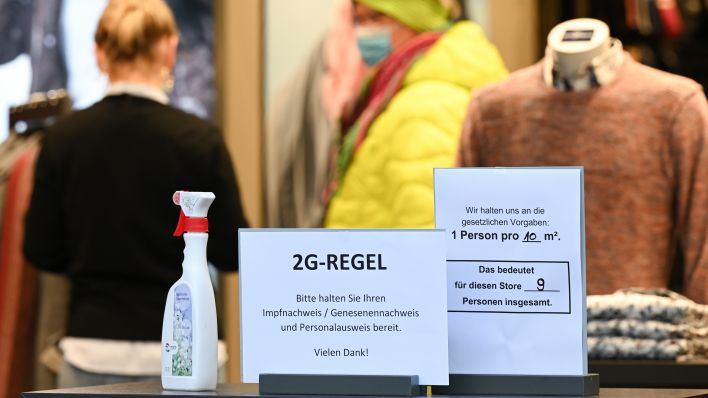 Am Eingang des Modegeschäfts Engbers in der Mainzer Innenstadt ist ein Schild mit der Aufschrift "2G-Regel. Bitte halten Sie Ihren Impfnachweis/Genesenennachweis und Personalausweis bereit. Vielen Dank!". Quelle: dpa/Arne Dedert