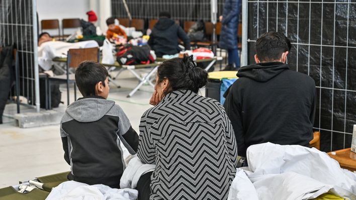Migranten sitzen in der neu eingerichteten zentralen Bearbeitungsstelle der Bundespolizei und des Bundesamtes für Migration und Flüchtlinge (BAMF) (Bild: dpa/Patrick Pleul)
