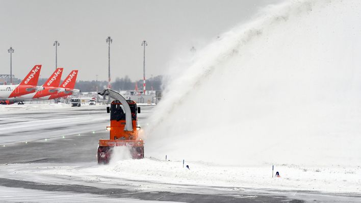 Eine Schneefräse bläst auf dem Flughafen Berlin Brandenburg «Willy Brandt» den Schnee von einer Rollbahn. (Quelle: dpa/Soeren Stache)