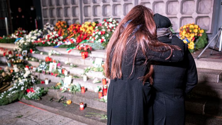 5. Jahrestag des Anschlags vom Breitscheidplatz: Angehörige eines der Opfer stehen am Mahnmal "Der Riss" vor Blumen und Kerzen, die dort im Gedenken an die Opfer niedergelegt wurden. (Quelle: dpa/Fabian Sommer)