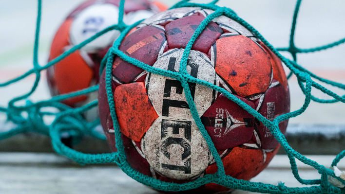 Ein Handball liegt in einem Tornetz. Quelle: imago images/foto2press