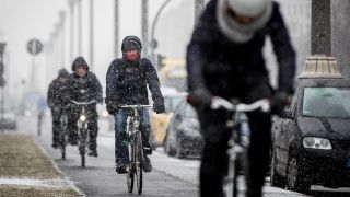 Passanten fahren auf Rädern in Friedrichshain durch den Schnee. (Quelle: dpa/Kay Nietfeld)