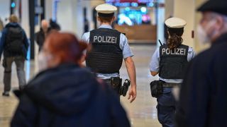 Zwei Polizeibeamte gehen durch das Terminal 1 vom Hauptstadtflughafen Berlin Brandenburg "Willy Brandt" (BER). (Quelle: dpa/Patrick Pleul)