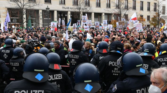 Teilnehmer einer Demonstration gegen die Corona-Einschränkungen der Bundesregierung und Polizisten stehen sich zwischen Brandenburger Tor und dem Reichstagsgebäude gegenüber. (Quelle: dpa/Paul Zinken)