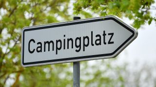 "Campingplatz" steht auf dem Wegweiser an der Zufahrt zu einem Campingplatz. (Quelle: dpa/Martin Schutt)