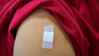 Eine Mitarbeiterin im Alten- und Pflegeheim Bürgerheim hat nach der Corona-Impfung mit dem Impfstoff von Biontech/Pfizer ein Pflaster auf dem Oberarm kleben. (Quelle: dpa/Sebastian Gollnow)