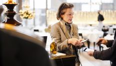 Eine Restaurant Inhaberin kontrolliert ein Covid-Zertifikat in Ihrem Restaurant (Quelle: dpa/Michael Buholzer)