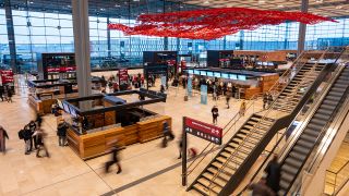 Menschen gehen im Dezember 2022 im Terminal 1 am Flughafen Berlin Brandenburg durch die Haupthalle. (Quelle: dpa/Christophe Gateau)