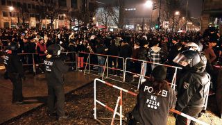Polizisten stehen am 31.12.2021 hinter einer Absperrung am Brandenburger Tor, wo sich mehrere hundert Menschen versammelt haben. (Quelle: dpa/Christophe Gateau)