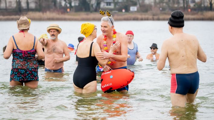 Winterschwimmer des Vereins "Berliner Seehunde" stehen am 01.01.2022 beim Neujahrsschwimmen im Orankesee. (Quelle: dpa/Christoph Soeder)