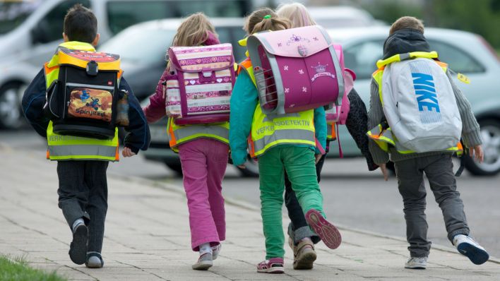Erstklässler der Grundschule mit ihren neuen leuchtend gelben Warnwesten auf dem Schulweg. (Quelle: dpa/Jens Büttner)
