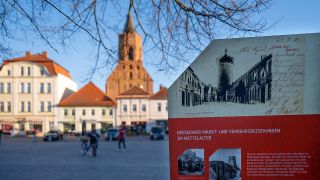 Symbolbild: Eine Tafel auf dem Marktplatz informiert über die mittelalterliche Geschichte der Stadt Beeskow. (Quelle: dpa/M. Skolimowska)