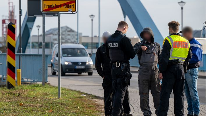 Polizisten kontrollieren auf der Grenzbrücke zwischen Deutschland und Polen drei Männer, die die Grenze zu Fuß überquerten. (Quelle: dpa/Monika Skolimowska)