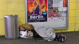 Schlafender Obdachloser neben einer Mülltonne morgens im Bahnhof Tempelhof. (Quelle: dpa/Matthias Tödt)