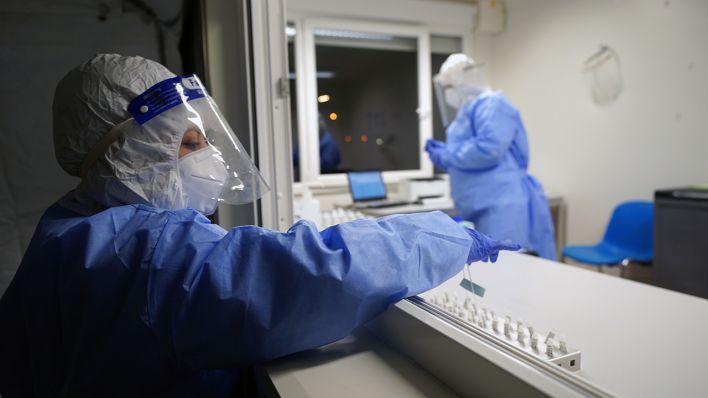 Eine Mitarbeiterin stellt eine Testprobe im Labor ab. (Quelle: dpa/Marcus Brandt)