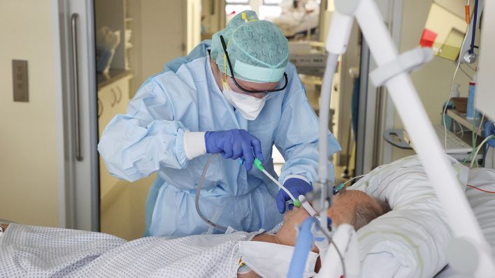 Ärzte und Pfleger untersuchen einen Patienten auf der Covid-19-Intensivstation. (Quelle: dpa/Bodo Schackow)