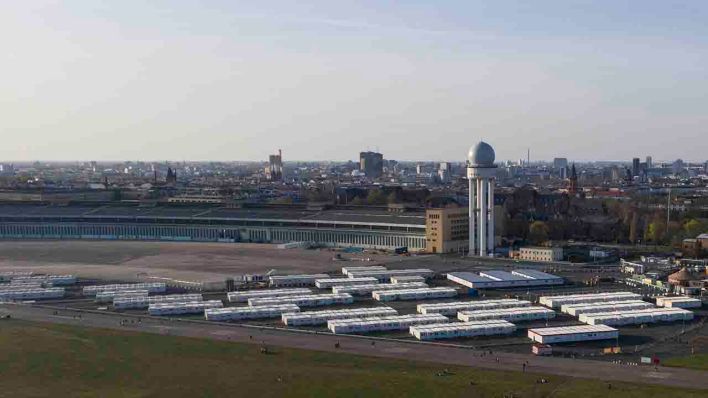 Die Luftaufnahme mit einer Drohne zeigt den Hangar des ehemaligen Flughafen Tempelhof. Davor sind die Container des ehemaligen Flüchtlingsdorfes zu sehen. (Quelle: dpa/Paul Zinken)