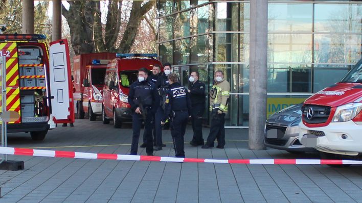 Polizisten stehen neben Krankenwagen und Fahrzeugen der Feuerwehr auf dem Gelände der Heidelberger Universität. (Quelle: dpa/D. Englert)