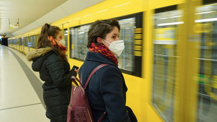 Symbolbild: Reisende stehen mit FFP2-Maske an einem U-Bahnhof in Berlin. (Quelle: dpa/J. Carstensen)
