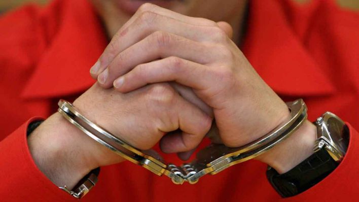 ARCHIV - Mit Handschellen gefesselt sitzt ein Mann vor Gericht (Quelle: dpa/Boris Roessler)