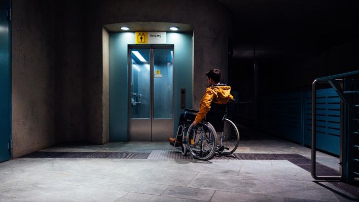 Ein Mann mit einem Rollstuhl auf einem Bahnhof vor einem Aufzug. (Quelle: dpa/Robert Schlesinger)