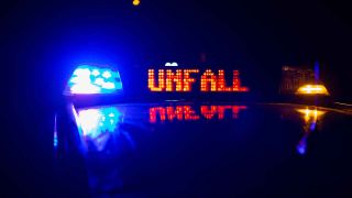 Ein Einsatzfahrzeug, Streifenwagen, der Polizei steht mit Blaulicht und dem Schriftzug Unfall im Display an einem Unfallort. (Quelle: Fotostand/Gelhot)