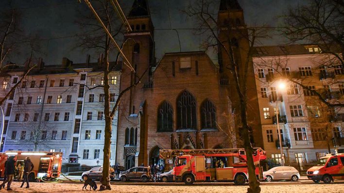 Nach einem Altar-Brand stehen mehrere Feuerwehrfahrzeuge vor der Paul Gerhardt-Kirche (Bild: Morris Pudwell)