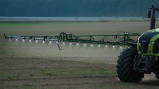 Ein Landwirt fährt am späten Abend mit einer Pestizid- und Düngerspritze über ein Feld in Brandenburg (Quelle: dpa/Patrick Pleul)