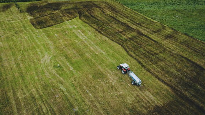 Ein Landwirt mit seinem Traktor bringt Gülle auf einem Feld aus. (Quelle: dpa/JFK)