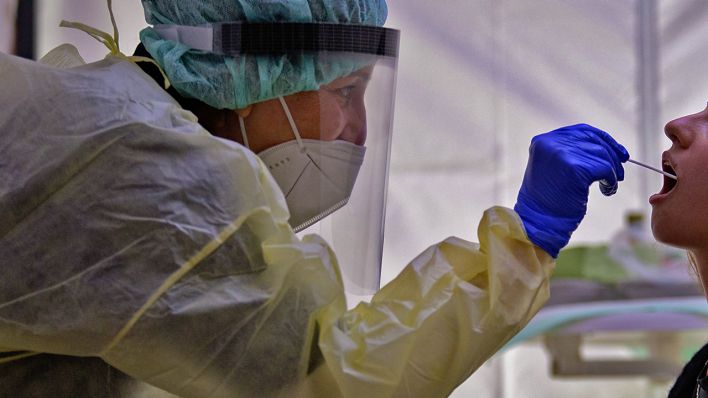 Eine DRK-Mitarbeiterin nimmt einen Nasenabstrich an einer Corona-Teststation. (Quelle: dpa/Soeren Stache)
