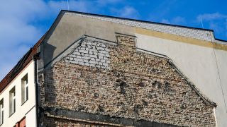 An der Fassade eines Wohnhauses sind noch die Spuren eines angrenzenden, abgerissenen Hauses zu sehen. Bild: dpa / Jens Kalaene