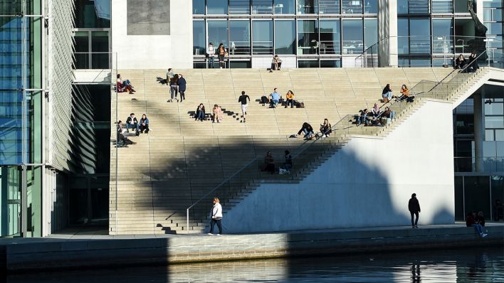 Symbolbild: Im Regierungsviertel sitzen am 02.03.2021 mehrere Personen auf einer Treppe vor dem Marie-Elisabeth-Lüders-Haus. (Quelle: dpa/Kira Hofmann)