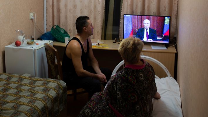 Menschen aus den Regionen Donezk und Luhansk verfolgen die Fernsehansprache des russischen Präsidenten Putin (Quelle: AP/Denis Kaminev)