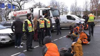 Archivbild: Polizisten beobachten Klimaschützer die mit dem Slogan «Essen retten» die Abfahrt der Berliner Stadtautobahn A100 unweit des ICC blockieren. (Quelle: dpa/P. Zinken)