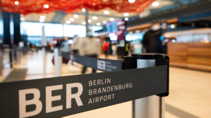 m Terminal 1 am Flughafen Berlin Brandenburg ist ein Absperrband mit der Aufschrift “BER - Berlin Brandenburg Airport”. Zum Start der Weihnachtsferien werden am Flughafen BER viele Fluggäste erwartet. (Quelle: Christophe Gateau/dpa)