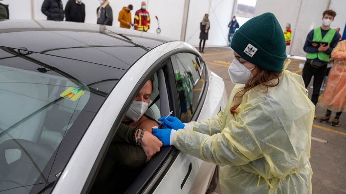 Ein Mann lässt sich in seinem Auto im Zelt des Impf Drive-In in Lichtenberg impfen. (Quelle: dpa/Christophe Gateau)