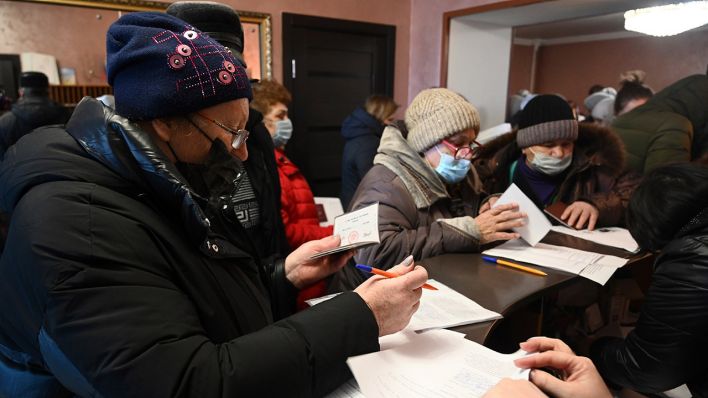 Menschen aus Donezk, dem von einer prorussischen Separatistenregierung kontrollierten Gebiet in der Ostukraine, versammeln sich nach ihrer Evakuierung, um Dokumente auszufüllen. (Quelle: dpa/AP)