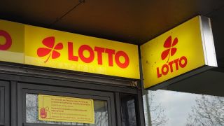 Schriftzug und Logo der Lottogesellschaft sind an einem Kiosk angebracht. (Quelle: dpa/Alexandra Schuler)