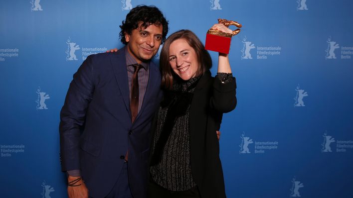 Berlinale-Jury-Präsident M. Night Shyamalan (L) und Regisseurin Carla Simon mit dem golenen Bären. (Quelle: dpa/R. Hartmann)
