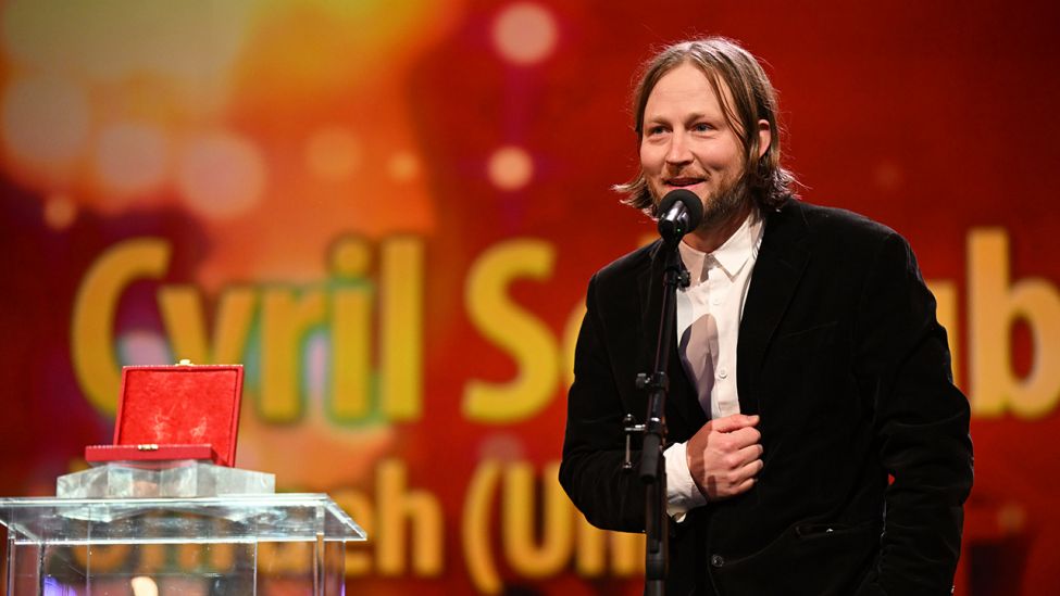 Cyril Schäublin gewinnt den Preis für die Beste Regie in der Kategorie Encounters für "Unrest" bei der Preisverleihung der Berlinale 2022 im Berlinale-Palast. (Quelle: dpa/M. Skolimowska)