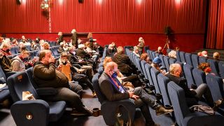Kinobesucher sitzen zur Premiere des Films "Komm mit mir in das Cinema - Die Gregors" mit Masken und Abstand im Kinosaal vom Delphi-Filmpalast. (Quelle: dpa/Jens Kalaene)
