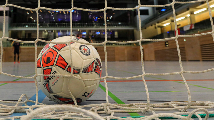 Ein Ball liegt im Netz eines Tores beim Hallenfußball (Bild: IMAGO/Beautiful Sports)