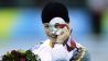 Claudia Pechstein guckt durch ihre Olympische Silbermedaille in Turin 2006 (imago images/Lacy Perenyi)