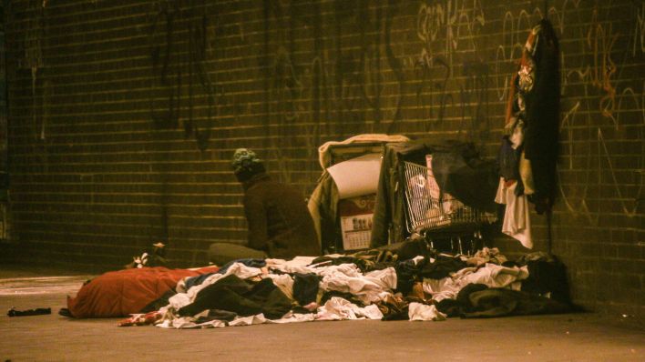 Ein Obdachloser sitzt unter einer S-Bahnbrücke in Berlin-Wilmersdorf. (Quelle: IMAGO / Rolf Kremming)