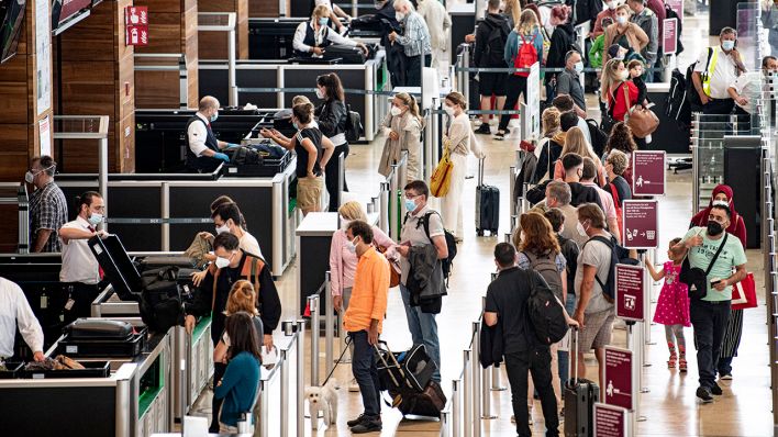 Reisende stehen am Flughafen am Security Check. (Quelle: dpa/Fabian Sommer)I